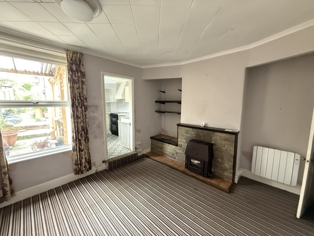 Lot: 142 - FREEHOLD TWO-BEDROOM HOUSE IN NEED OF IMPROVEMENT - Dining room with carpet and kitchen beyond